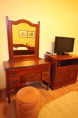 a bedroom with a dresser with a mirror and a television at Hotel Laguna in Podgorica