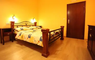 a bedroom with a bed and a wooden floor at Hotel Laguna in Podgorica