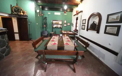 a dining room with a table and chairs and green walls at Hotel Laguna in Podgorica