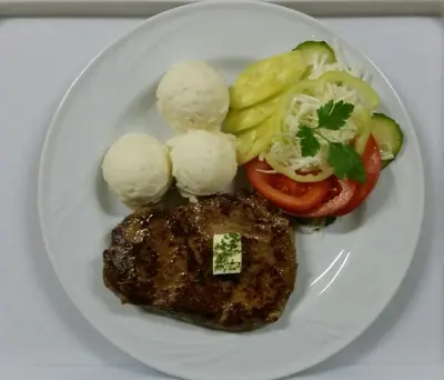 a plate of food with meat and vegetables on it at Hotel Laguna in Podgorica