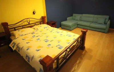a bedroom with a bed and a couch at Hotel Laguna in Podgorica