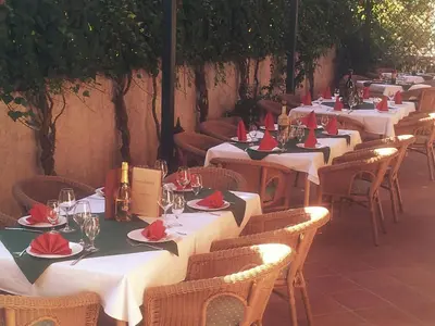 a row of tables and chairs with red napkins at Hotel Laguna in Podgorica