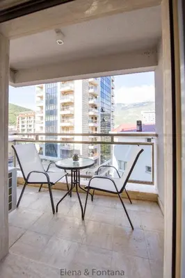 a balcony with two chairs and a table and a window at Elena&Fontana Apartment in Budva