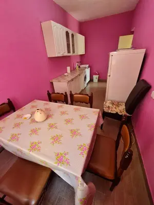 a dining room with a table and a purple wall at Apartment Dragone in Ulcinj