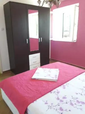 a bedroom with a bed with a pink wall at Apartment Dragone in Ulcinj