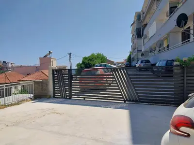 a gate in a parking lot with some stairs at Apartment Dragone in Ulcinj
