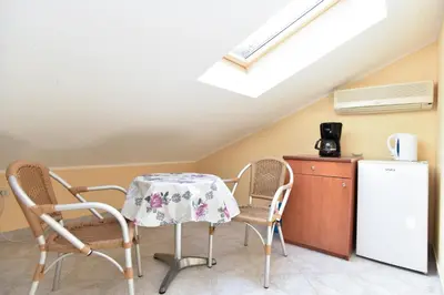 a kitchen with a table and chairs and a refrigerator at Apartments Mara in Budva