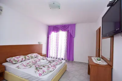 a hotel room with a bed and a television at Apartments Mara in Budva