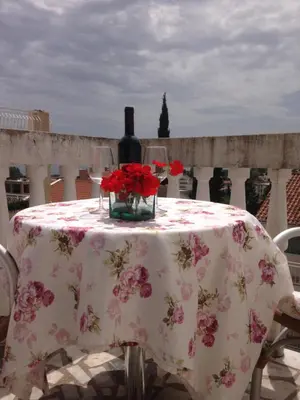 a table with a bottle of wine and flowers on it at Apartments Mara in Budva