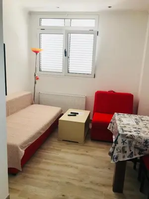 a small room with a bed and a red chair at Guest House Ratko in Rafailovici