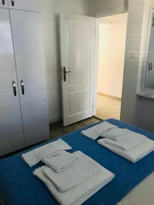 a group of white towels sitting on a blue bed at Guest House Ratko in Rafailovici