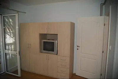 a room with a door and a tv on a cabinet at Guest House Ratko in Rafailovici