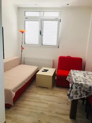a small room with a bed and a red chair at Guest House Ratko in Rafailovici