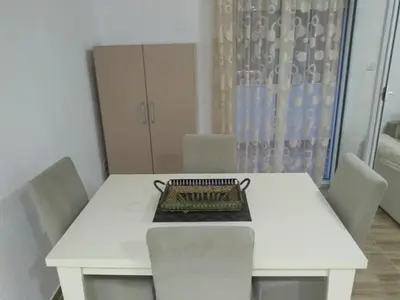 a white dining room table with chairs and a cabinet at Guesthouse Marko in Becici