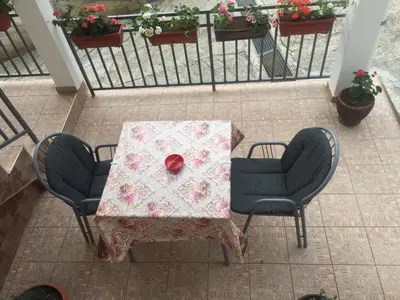 a table with two chairs and a red object on it at Guesthouse Marko in Becici