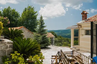 a patio with chairs and a house with a view at Villa Dub in Kotor