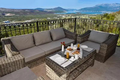 a patio with a couch and a table on a balcony at Villa Dub in Kotor