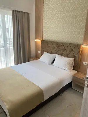 a bedroom with a large bed with a large window at Apartments Vila Sara M in Ulcinj