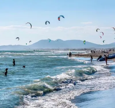 a group of people flying kites on a beach at Apartments Vila Sara M in Ulcinj