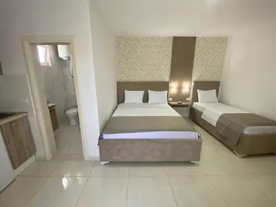 a hotel room with two beds and a bathroom at Apartments Vila Sara M in Ulcinj
