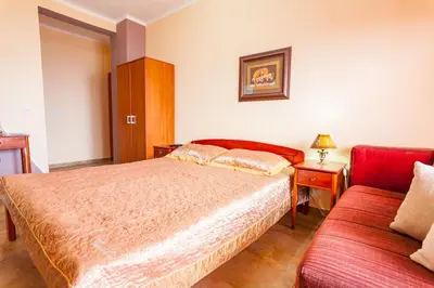a bedroom with a bed and a red couch at Vongola in Utjeha