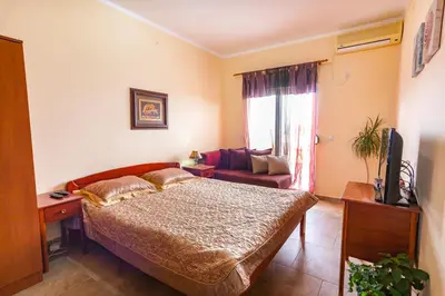 a bedroom with a bed and a couch at Vongola in Utjeha