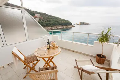a balcony with a table and chairs and the ocean at Vongola in Utjeha