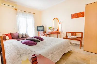 a bedroom with a large bed with purple pillows at Vongola in Utjeha