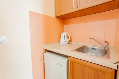 a small kitchen with a sink and a refrigerator at Vongola in Utjeha