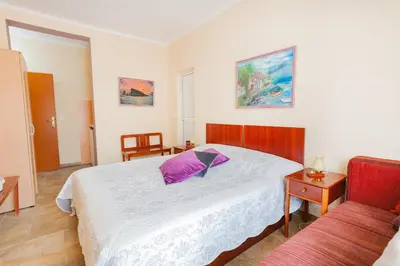 a bedroom with a large bed with a purple pillow at Vongola in Utjeha
