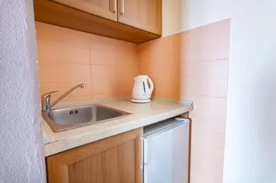 a small kitchen with a sink and a refrigerator at Vongola in Utjeha