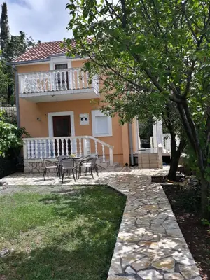 a house with a table and chairs in the yard at House Stijepovic in Petrovac na Moru