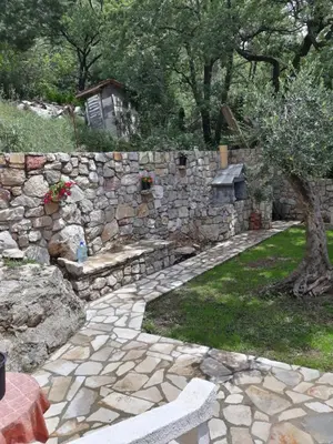 a stone wall with a bench and a tree at House Stijepovic in Petrovac na Moru