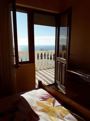 a bedroom with a view of the ocean from a window at House Stijepovic in Petrovac na Moru