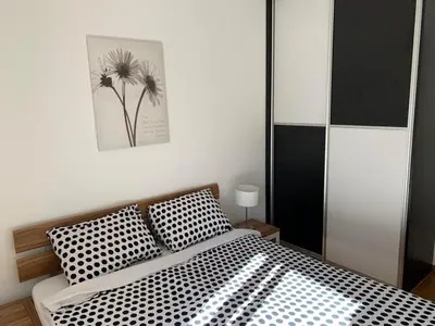 a bedroom with a bed with black and white pillows at Apartments City Life in Podgorica