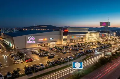 a parking lot with cars parked in front of a building at Apartments City Life in Podgorica