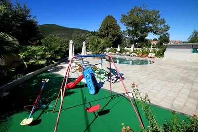 a swing set in front of a swimming pool at Hotel Aruba in Budva