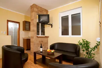 a living room with two leather chairs and a table at Castellamare Residence in Petrovac na Moru