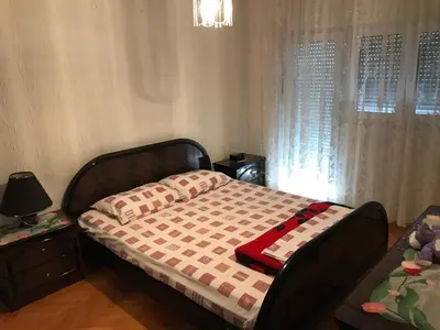 a bedroom with a bed with a red and white blanket at Holiday Home Celuga in Bar