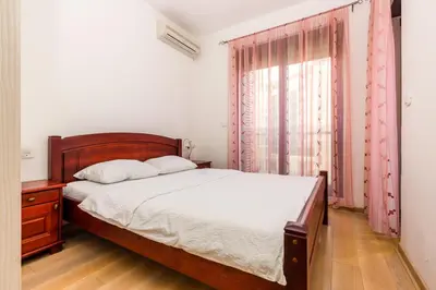 a bedroom with a bed and a large window at Sea View Apartments Perovic in Budva