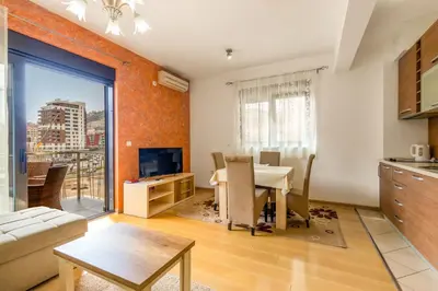 a living room with a table and a kitchen at Sea View Apartments Perovic in Budva