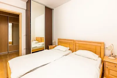 two beds in a bedroom with a mirror at Sea View Apartments Perovic in Budva