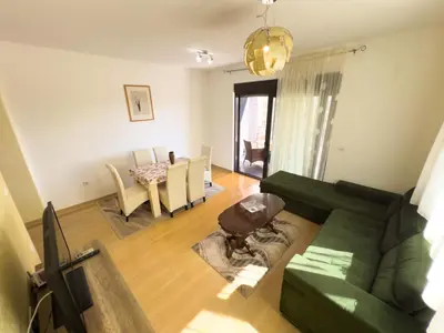a living room with a green couch and a table at Sea View Apartments Perovic in Budva