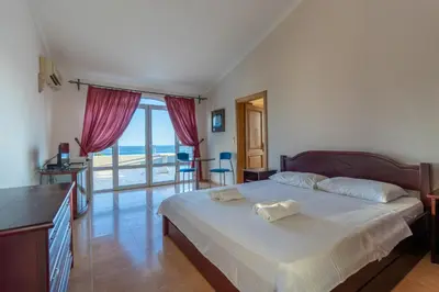 a bedroom with a bed and a view of the ocean at Blue Sky Apartments-Ulcinj, Montenegro in Ulcinj