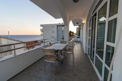 a balcony with a table and chairs and the ocean at Blue Sky Apartments-Ulcinj, Montenegro in Ulcinj