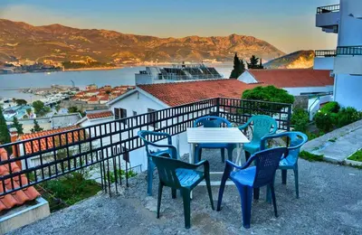a table and chairs on a balcony with a view at Apartmani Cupic in Budva
