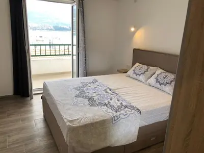 a bedroom with a bed and a large window at Apartmani Cupic in Budva