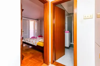 a room with a bed and a door leading to a bedroom at Apartment Mario in Budva