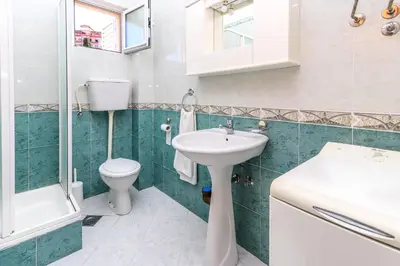 a bathroom with a white sink and a toilet at Apartment Mario in Budva