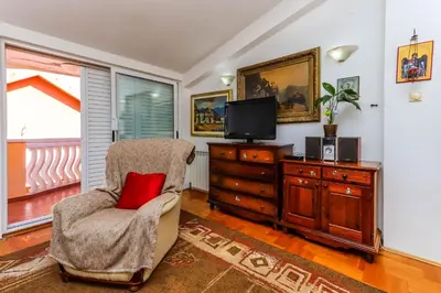 a living room with a chair and a television at Apartment Mario in Budva